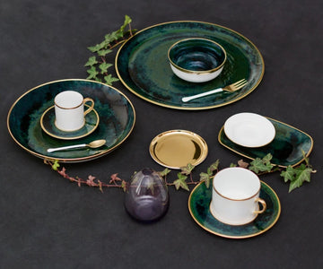 Lush Forest Tea Cup and Saucer shown with other coordinating dinnerware and a strand of ivy