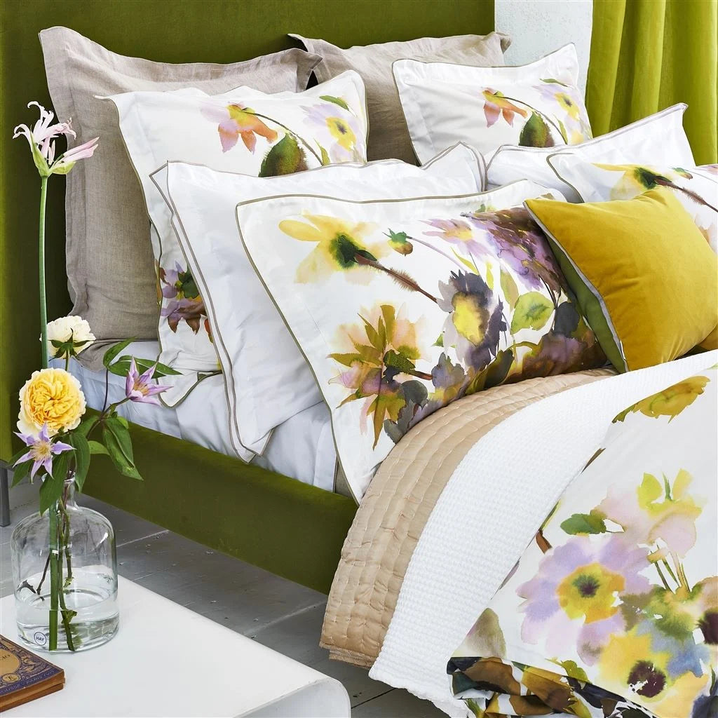 Palace Flower Birch Bedding shown on bed seen from the side with vase of flowers in foreground