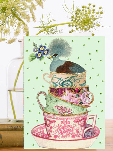 Decorative greeting card with stacked teacups and a bird on a light green background.