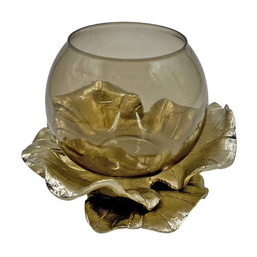 Decorative glass candle holder with gold leaf design on a white background