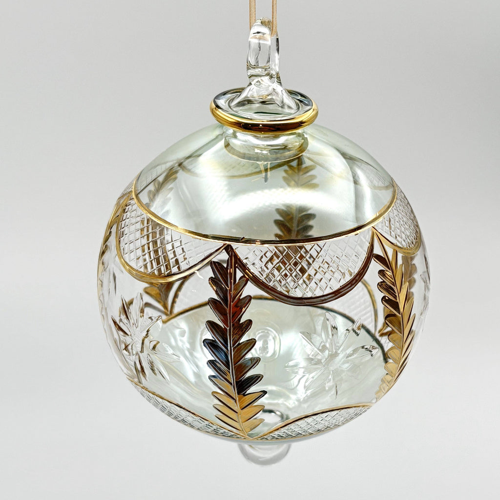 Decorative light green glass ornament with gold and silver leaf patterns 