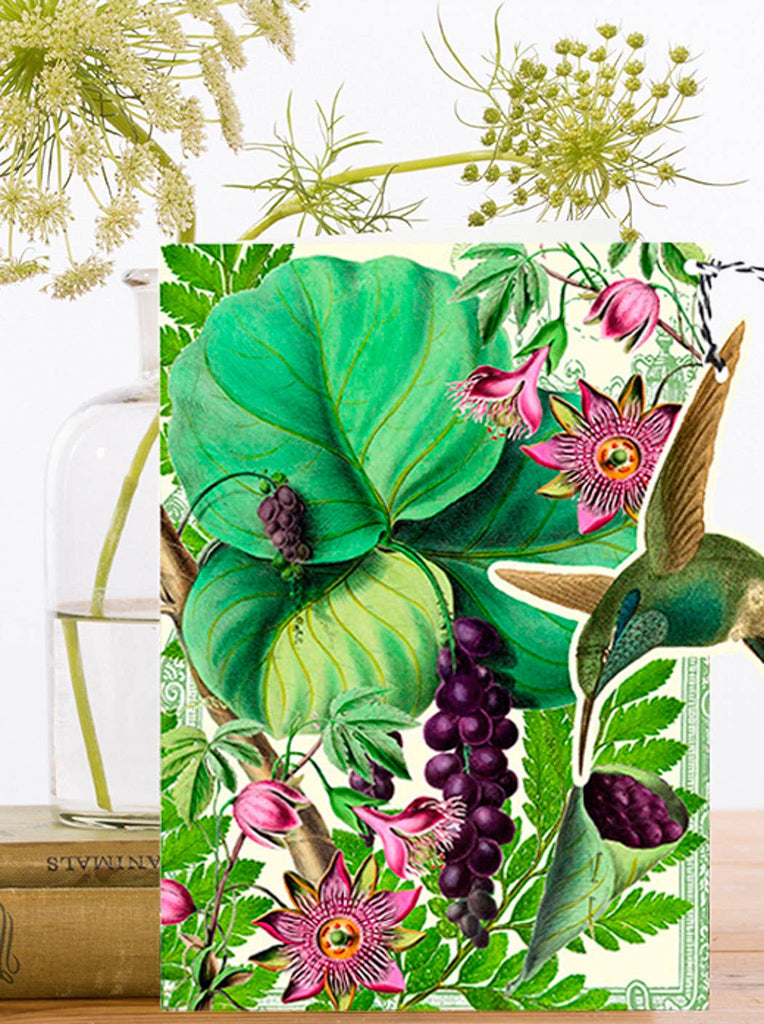 Decorative card with a colorful illustration of plants and flowers on a white background and a detachable hummingbird ornament.