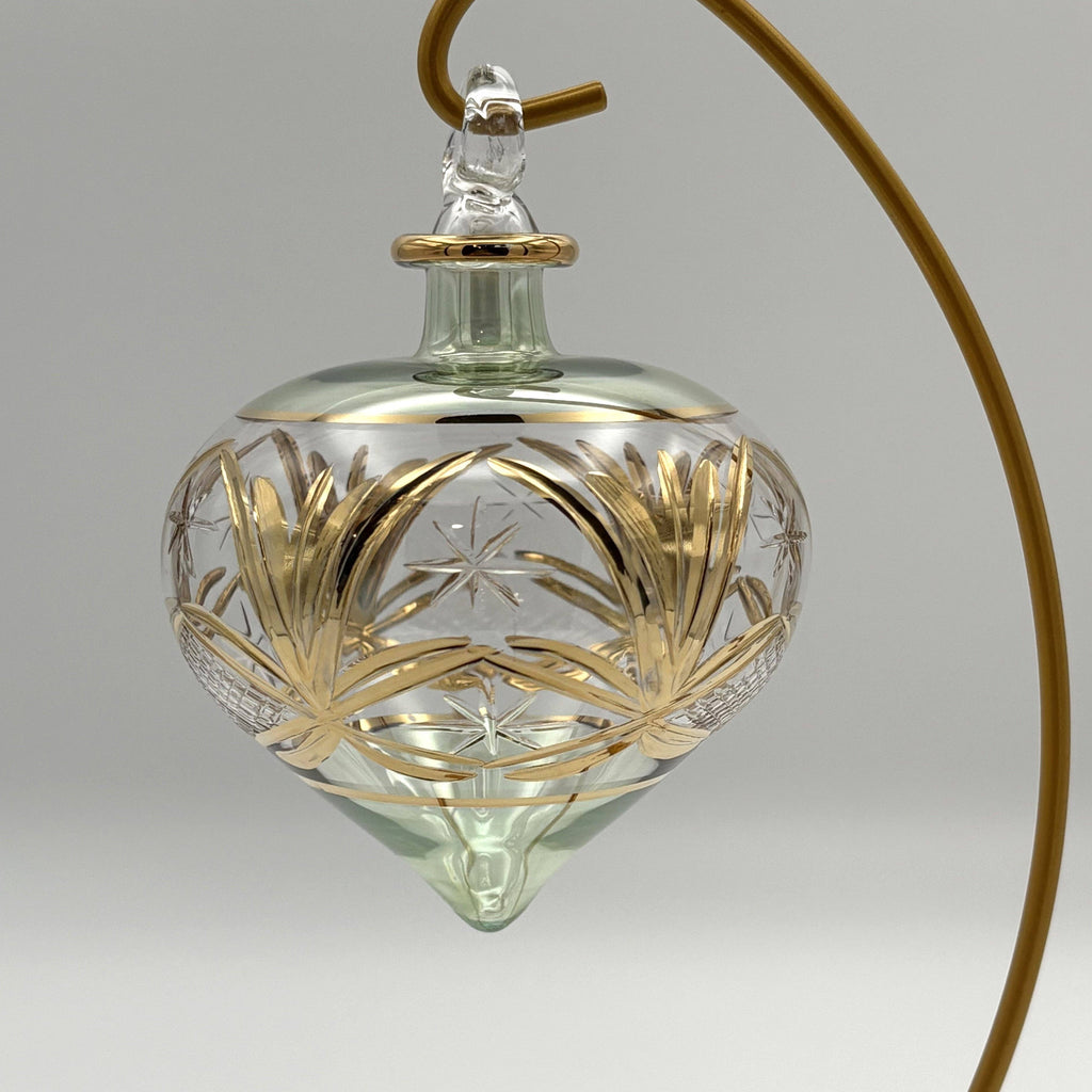 Decorative drop glass ornament  in a green tone with gold accents 