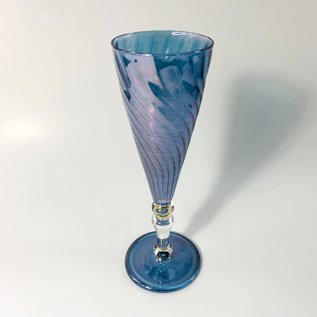 Handblown blue glass champagne flute with contrasting clear stem. Swirled glass motif for main part.