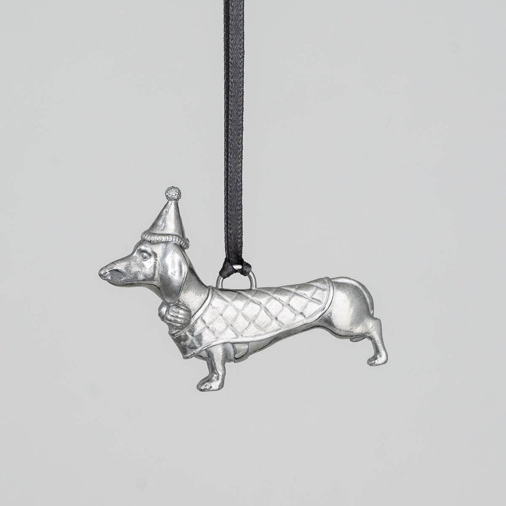 Pewter dachshund pendant with a bobble hat and coat on a gray background
