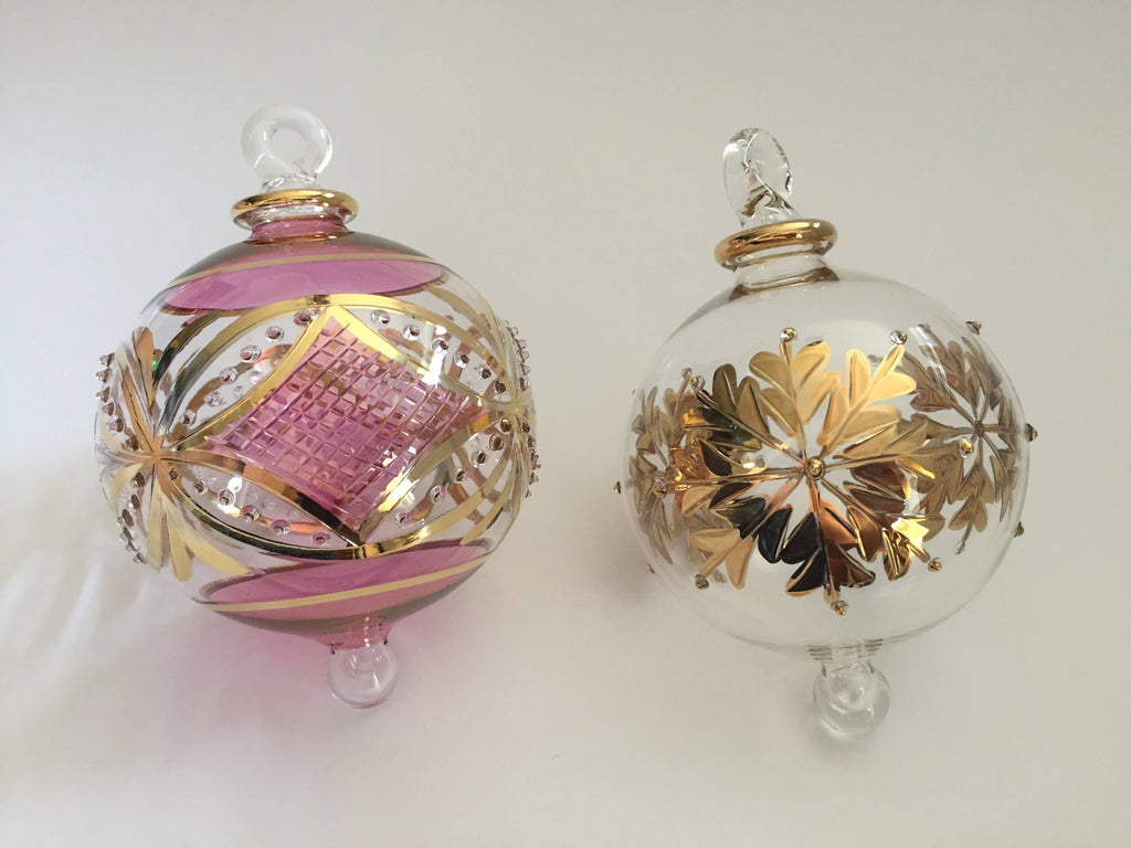 Two decorative Christmas ornaments with gold and pink designs 
