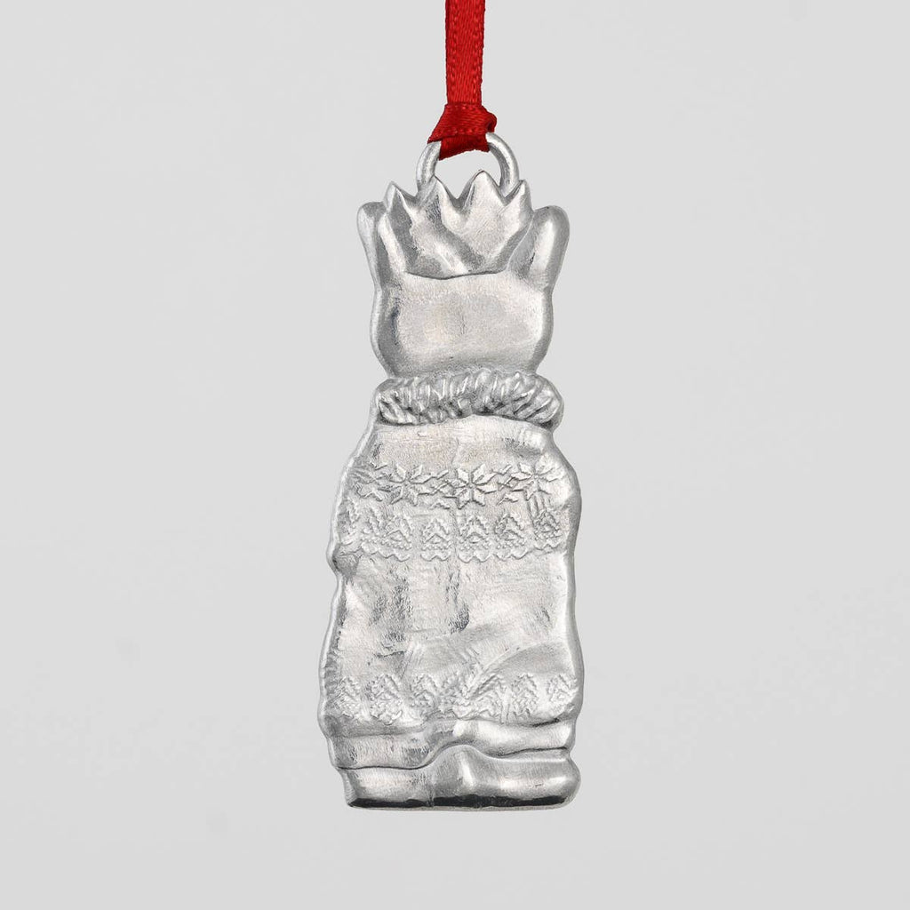 Pewter cat-shaped ornament with a crown, scarf and sweater on a gray background