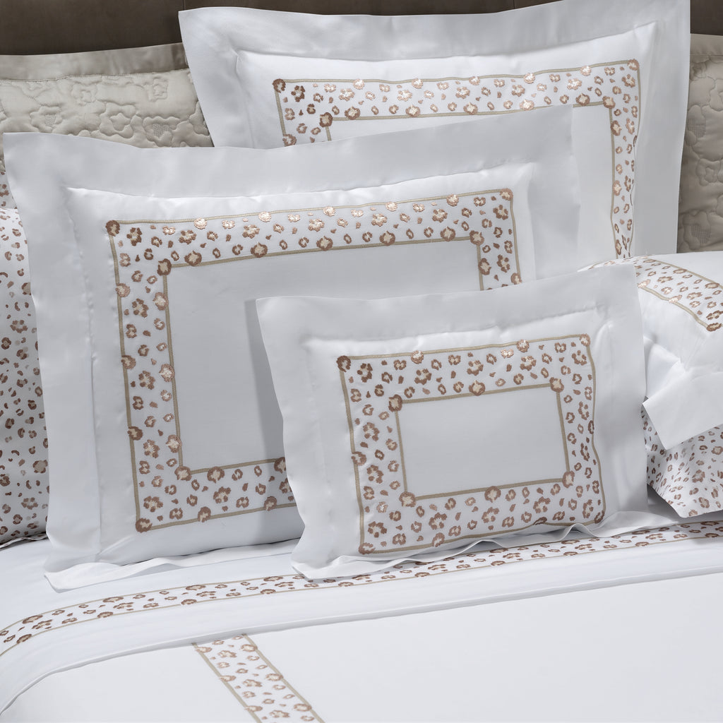 Bed with floral patterned bedding and pillows in a bedroom setting.