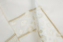 Close-up of an Ivory cotton fabric with muted gold embroidery details on the flat sheet. The frame embroidery captures the fine leopard patterns