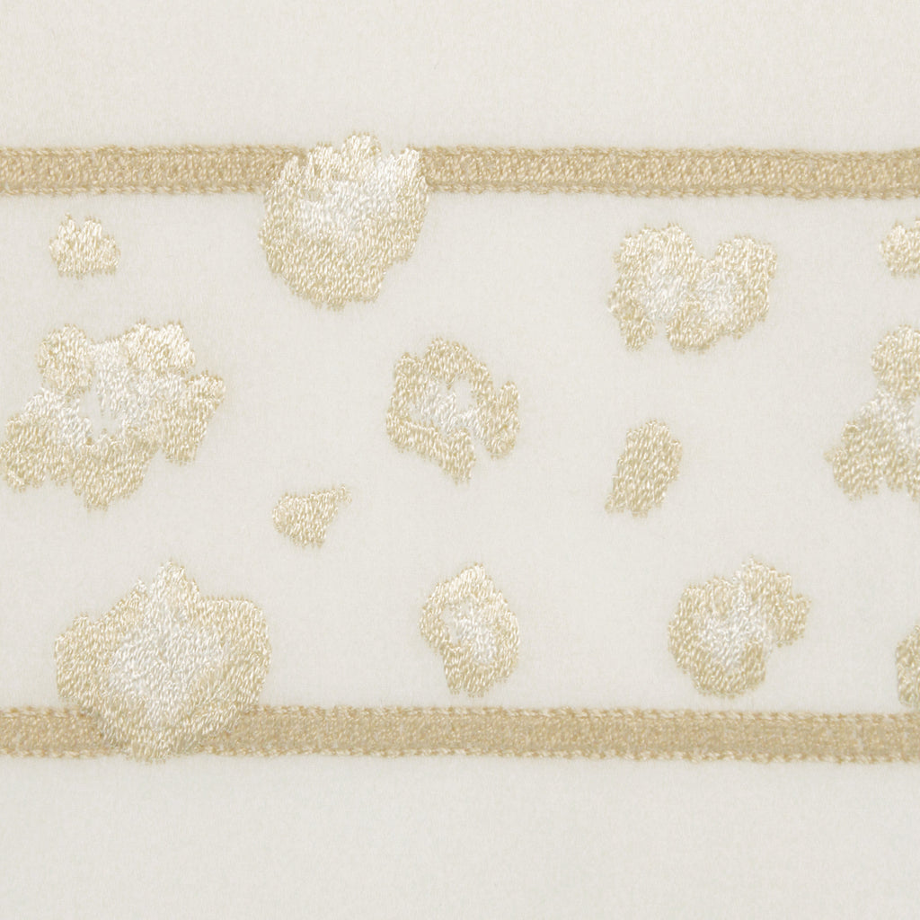 Close-up of a decorative leopard embroidery pattern for pillowcases and sheets on an Ivory cotton fabric.