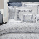 Bed with floral-patterned bedding and pillows in a bedroom setting.