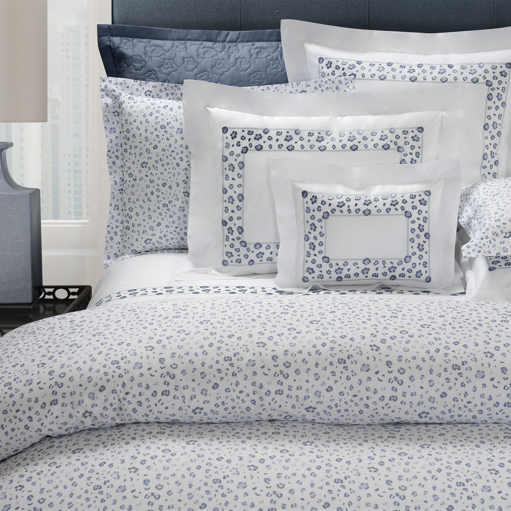 Bed with floral-patterned bedding and pillows in a bedroom setting.