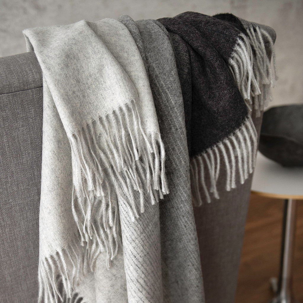 Aria throws in the colour Charcoal. The throw has a soft gradient from light grey to black with line details.