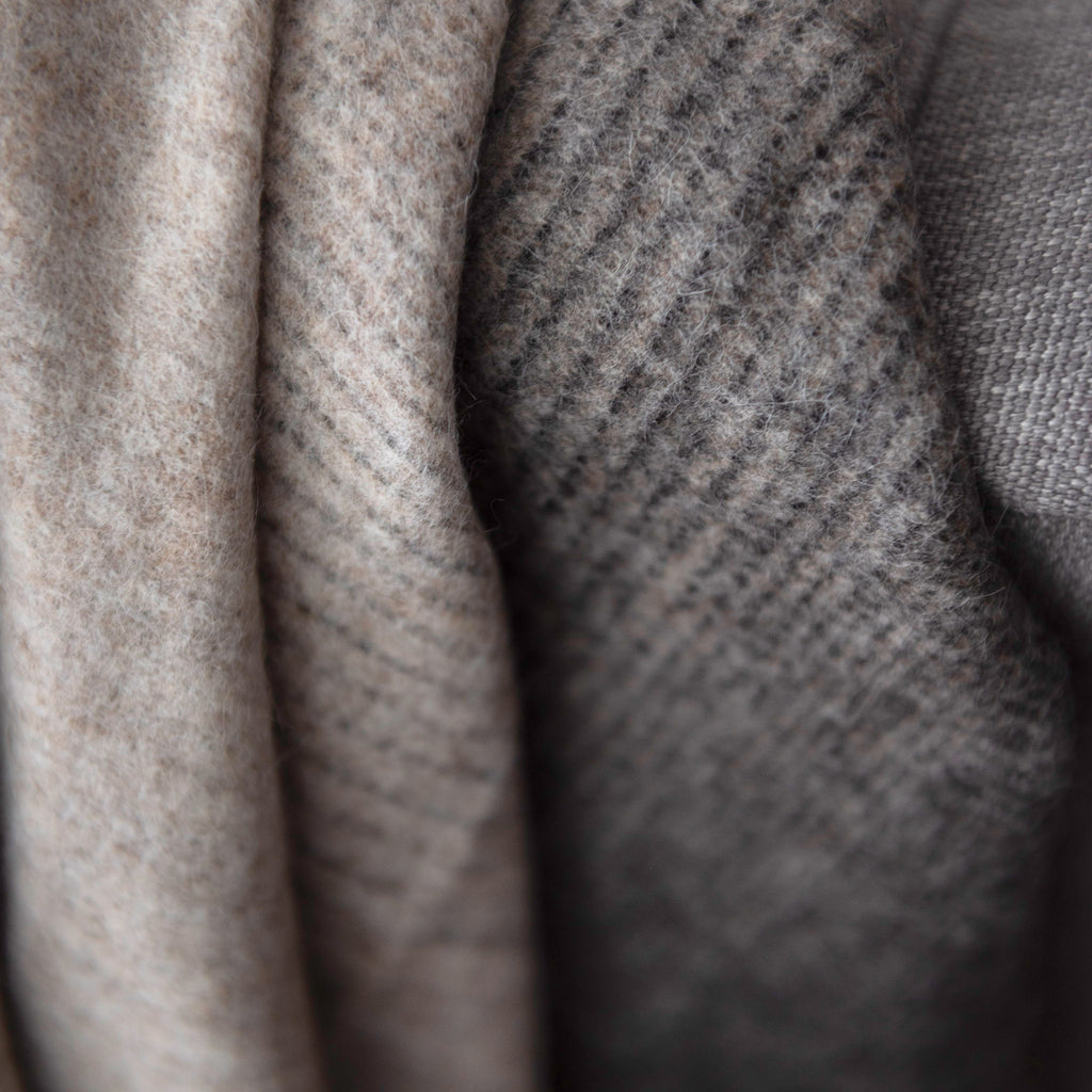 Closeup of Aria throw in the colour Crimini, showing the warm gradient with line details that gently connects the taupe to darker brown colour