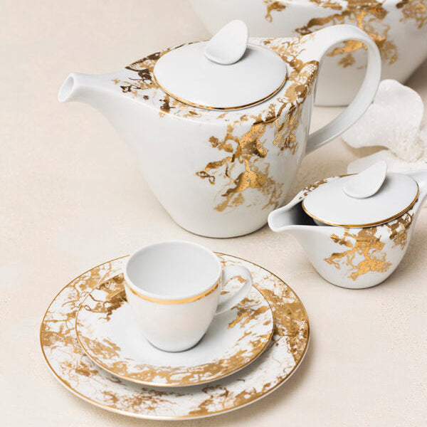 White teapot, cup, and saucer set with gold floral patterns