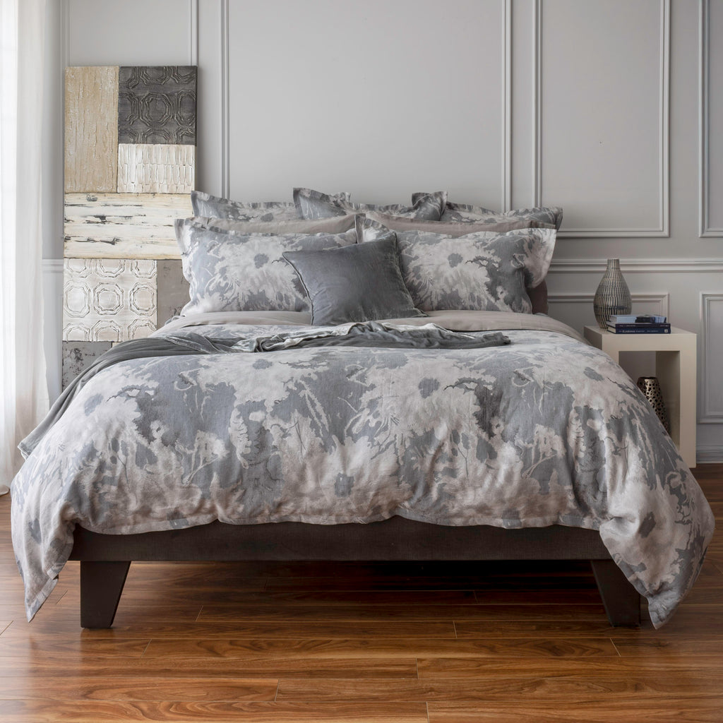 Blossom Moonlight bedding with duvet cover and shams. Paired with Capri Platinum flatsheet and pillowcases. Add a touch of texture with Divina cushion and throw