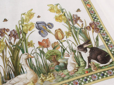 Italian tea towel of a garden scene with ducks, rabbits, a mouse and flowers