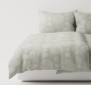 Stone/light gray textured bedding set on a bed
