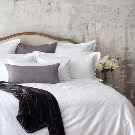 Textured white bedding set up on the bed