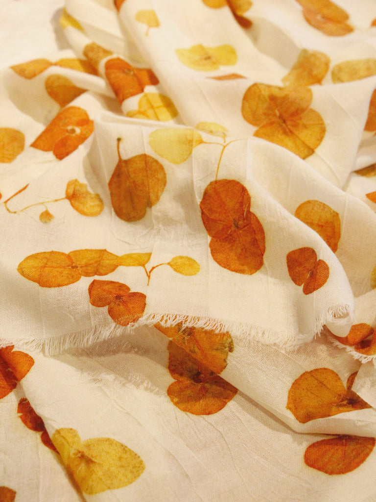 Tati Eco Print Orange Fall Scarf with round orange leaf patterns. Close Up Photo