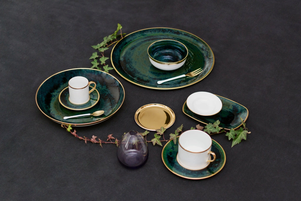 Lush Forest Tea Cup and Saucer shown with other coordinating dinnerware and a strand of ivy