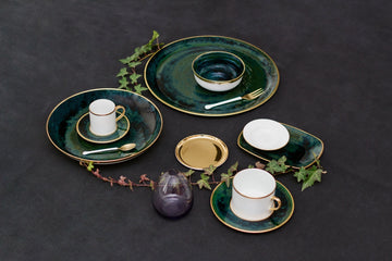 Lush Forest Tea Cup and Saucer shown with other coordinating dinnerware and a strand of ivy