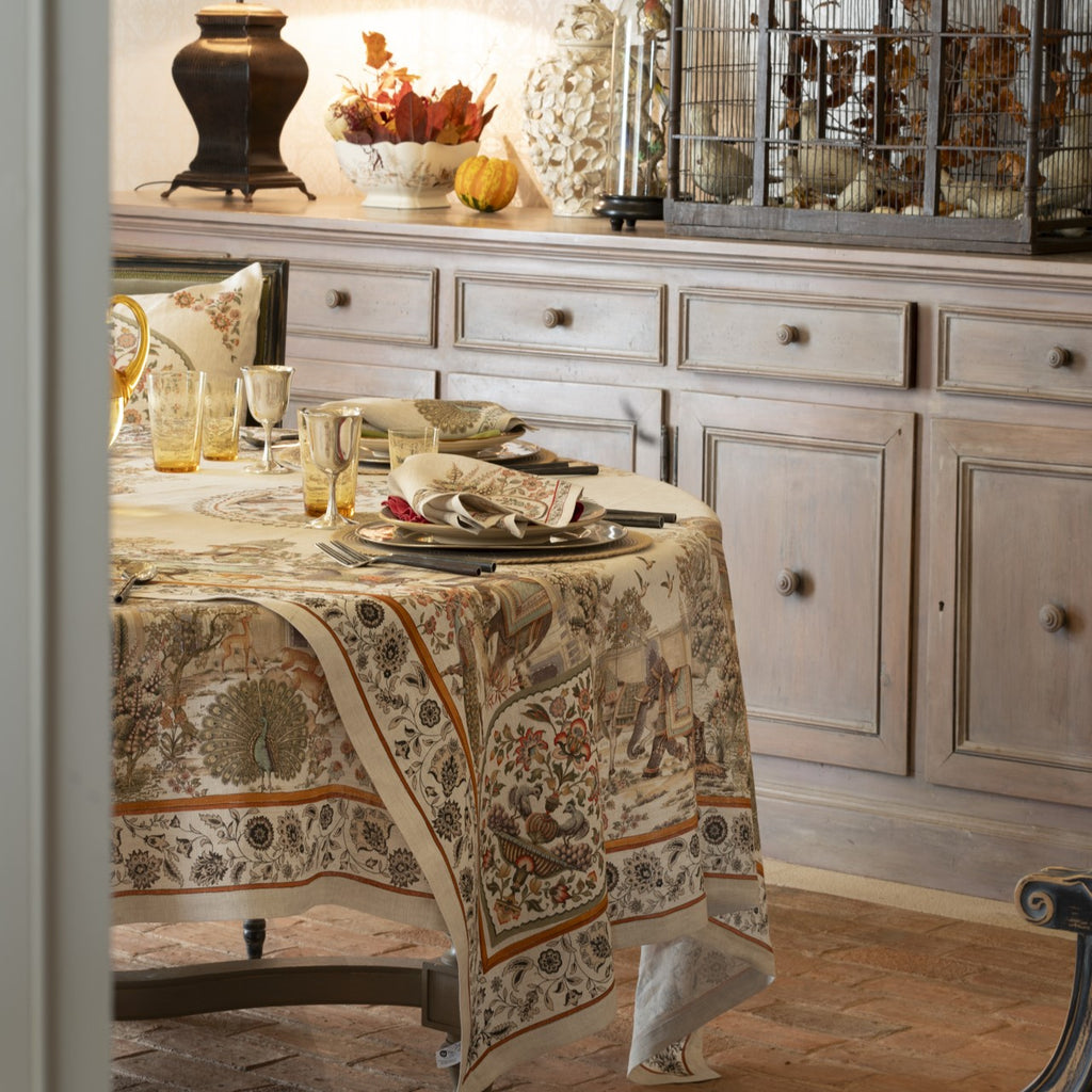 Dining room with a table set for a meal, featuring a patterned tablecloth and decorative items.