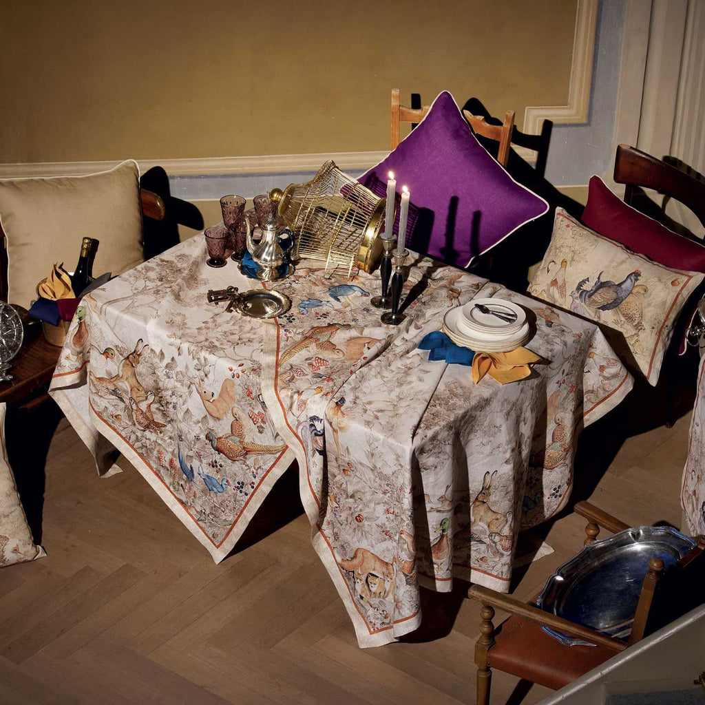 Tablecloth design featuring birds and rabbits on a beige background.