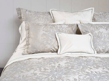 Noto Beige/ Wilton Blue shams on bed with light coloured shams in centre