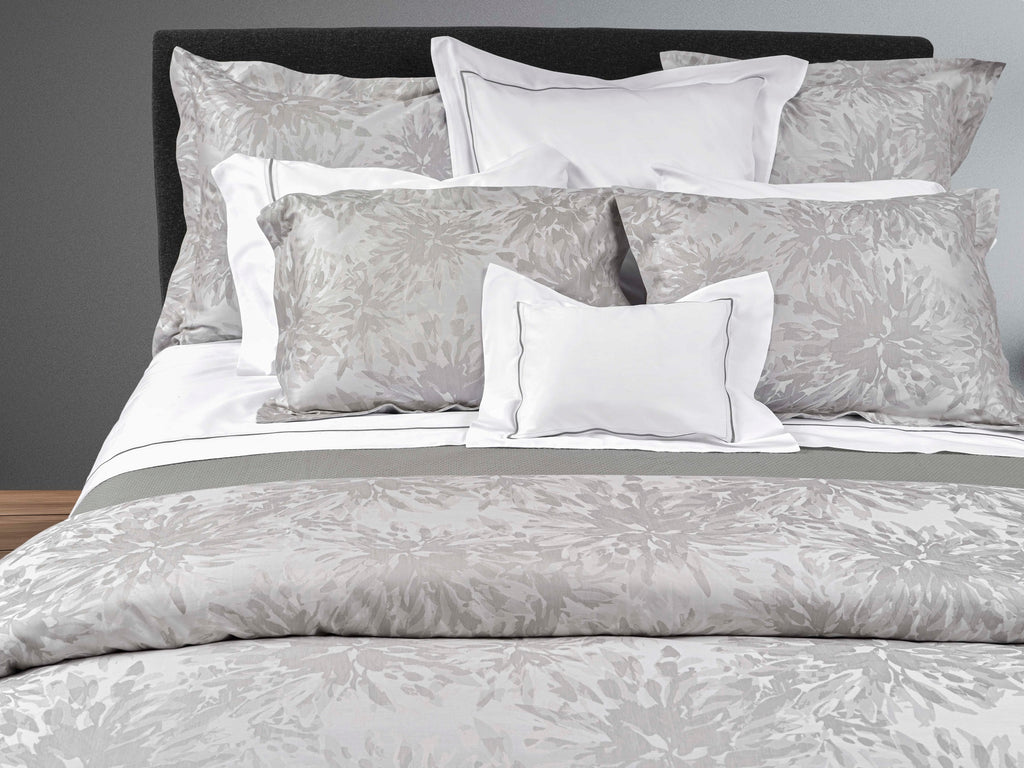 Noto Grey bedding on bed with white shams with grey trim in centre