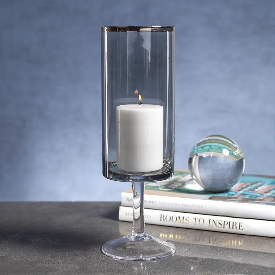 Banco Luster Black Hurricane with Platinum Rim with lit candle inside next to two books lain flat on table with a glass ball on top