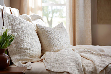Shams and Coverlet in light beige colour placed on the bed 