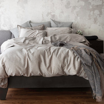 Rio Walnut bedding display with duvet cover and pillowcases. Paired with Capri Taupe pillowcases and shams. Adding in decorative elements of Zora euro shams, and Reneta throw.