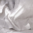 Close-up of white satin fabric with subtle texture