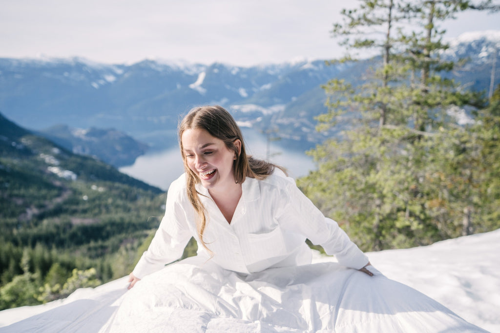 Person holding Eiderdown duvet against backdrop of mountains and ocean