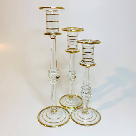 Set of three clear glass candle holders with gold bases