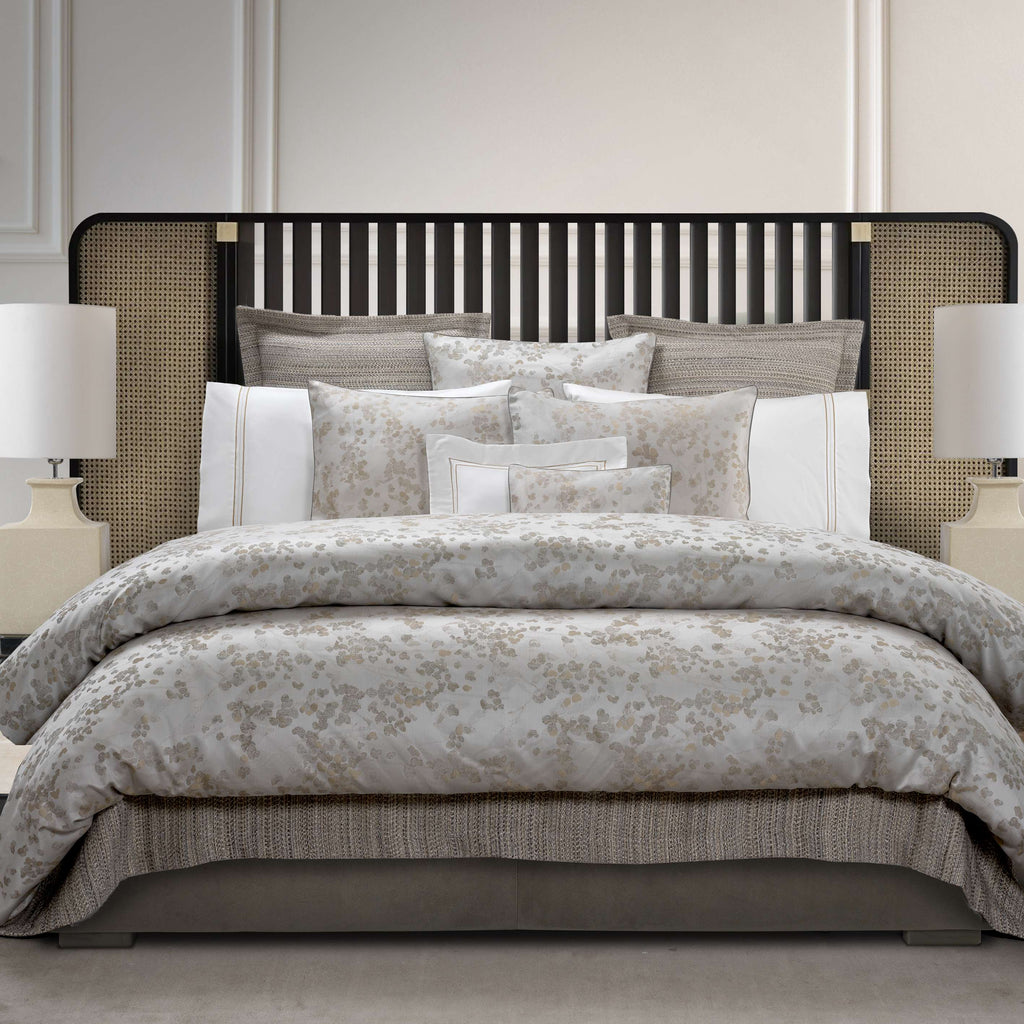 Neatly made bed with floral jacquard bedding 