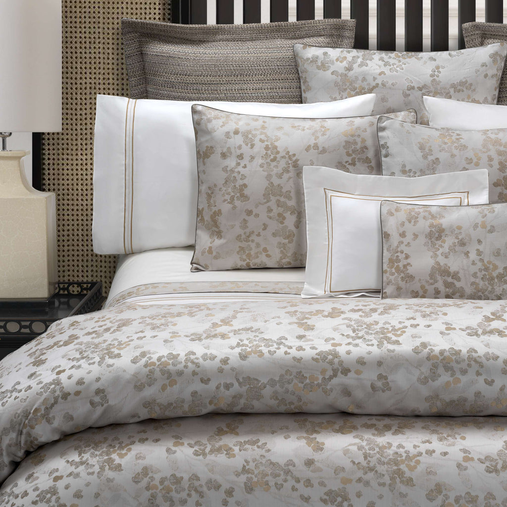 Neatly made bed with floral jacquard bedding 