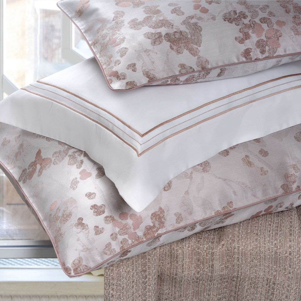 Floral patterned pillowcases on a bed with a neutral background