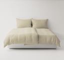 Ivory/lenen textured bedding set up on a bed