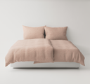 Pink textured bedding set up on a bed