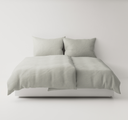 Light grey textured bedding set up on a bed