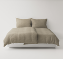 Light brown textured bedding set up on a bed