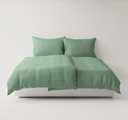 Green textured bedding set up on a bed