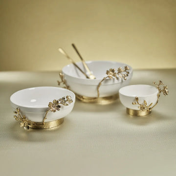 Trio of Tavolo ceramic bowls with floral trim shown on table, medium to the left, large in the centre with cutlery placed inside and small to the right