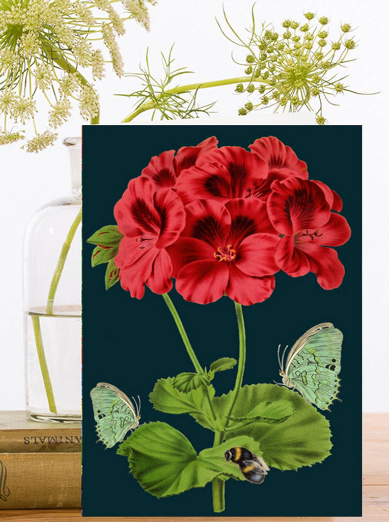 Greeting card with illustration of red flowers with green leaves and butterflies on a dark blue background.
