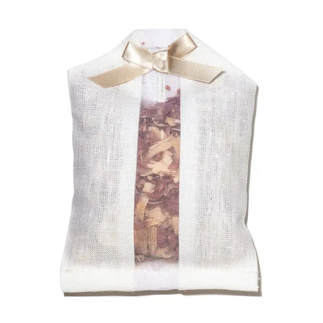 Ivory sachet with sheer centre fabric showing cedar chips inside. Ribbon in bow at top.