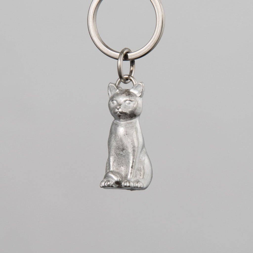 Pewter cat-shaped keychain on a gray background