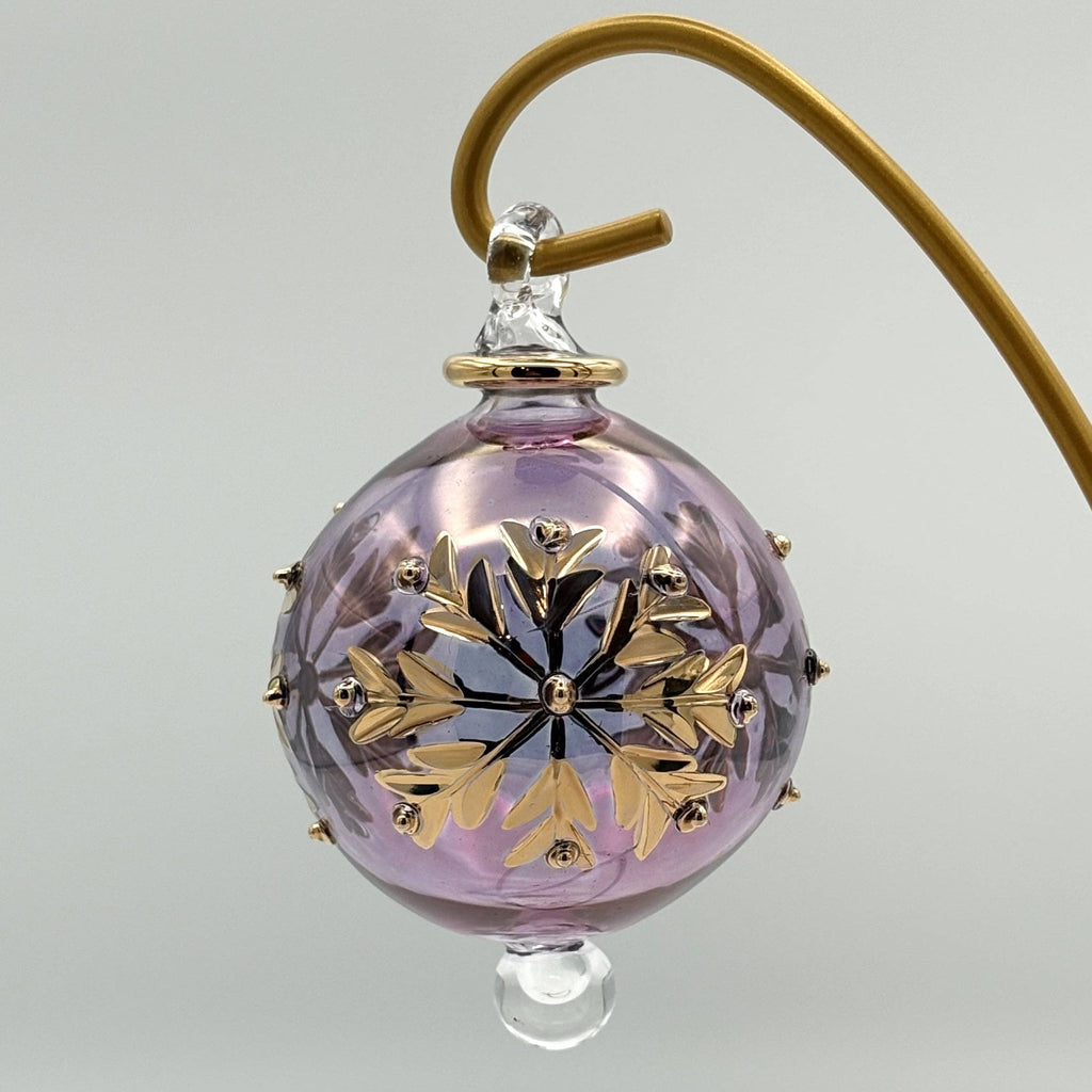 Decorative pink glass ball with gold leaf design  