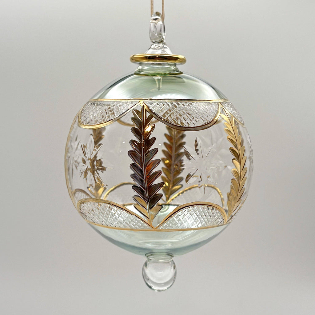 Decorative light green glass ornament with gold and silver leaf patterns 